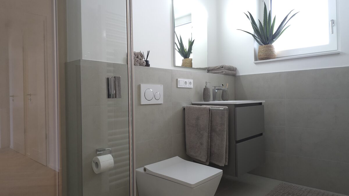 Musterwohnung: Duschbad mit Glasabtrennung und Hängetoilette
